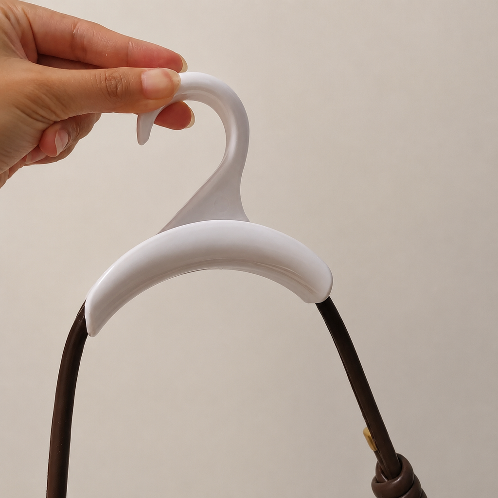 White closet purse and hat hook shown by hand for scale