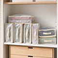 Clear foldable bedding storage bags neatly organized on a modern closet shelf