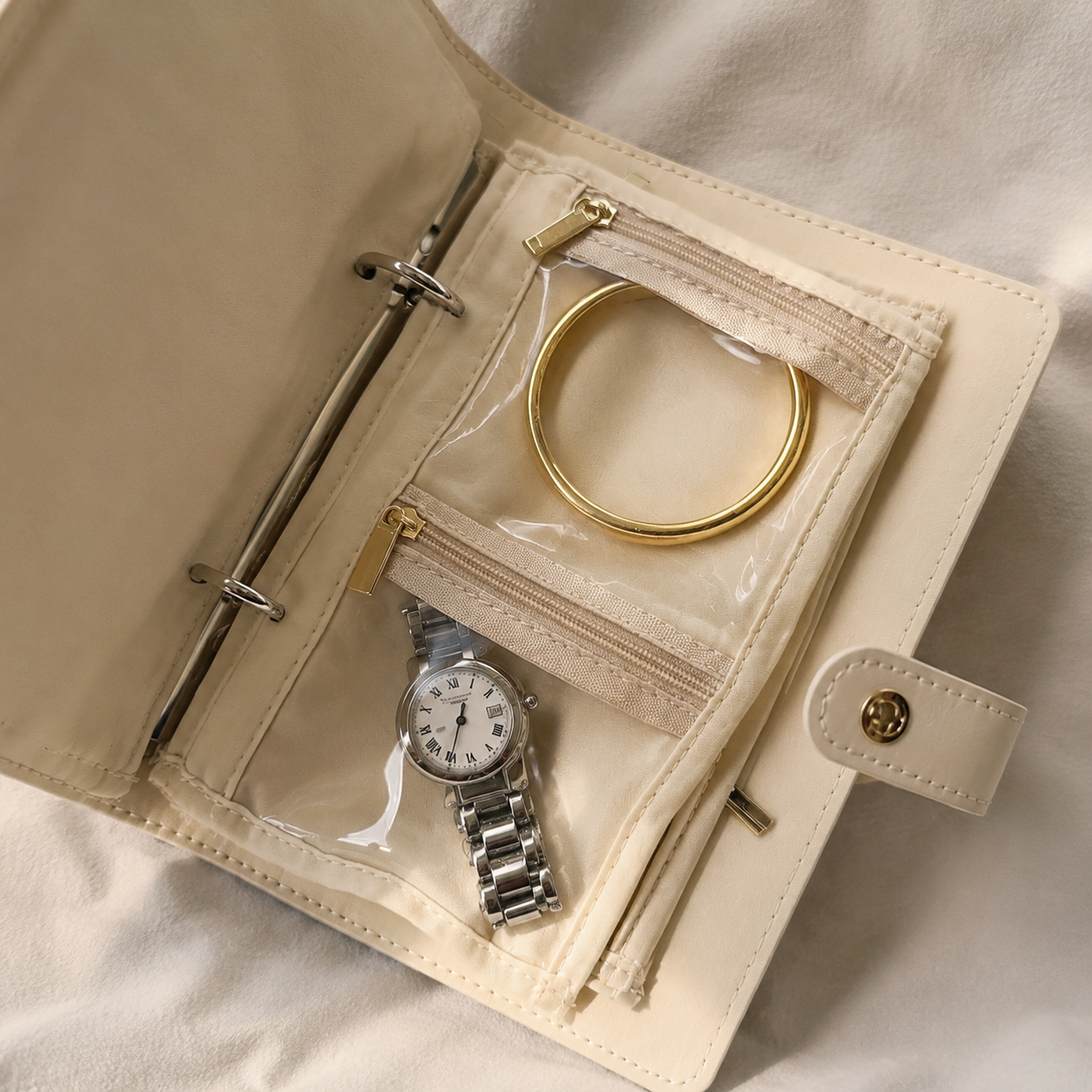 Detail view of binder rings and clear zipper pockets inside the travel jewelry organizer book