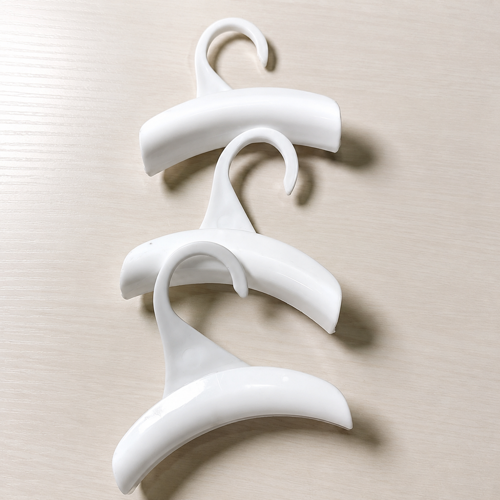 Three white closet accessory hooks arranged as a set