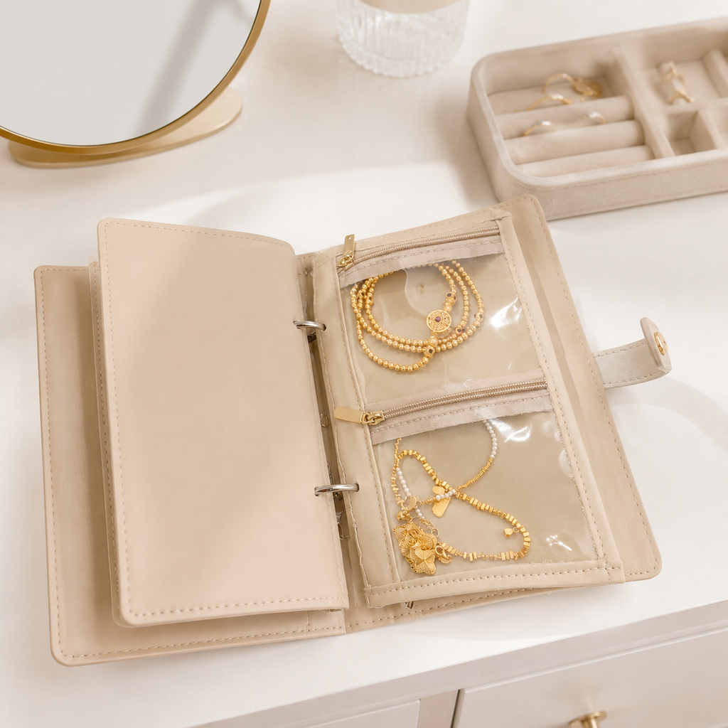 Open travel jewelry organizer book styled on a clean dressing table with jewelry