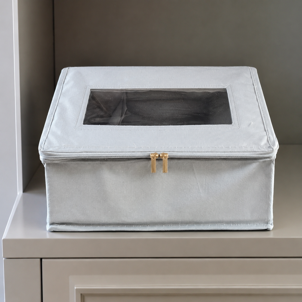 Real detail view of the closed clear-window hat storage box on a cabinet