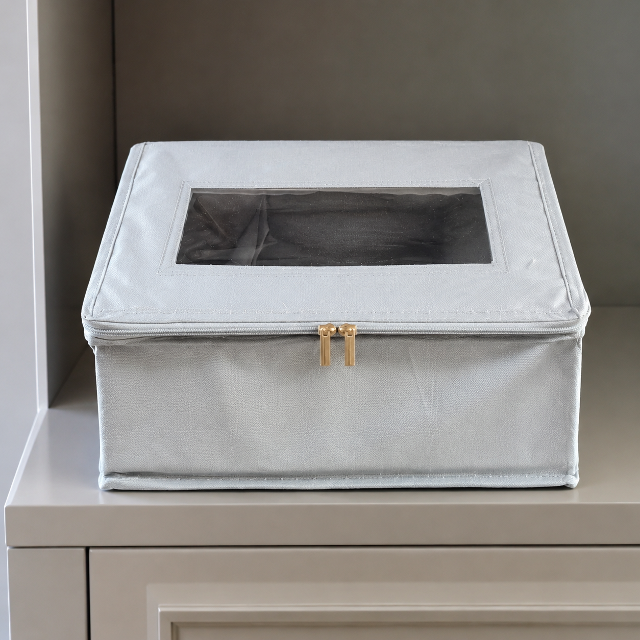 Real detail view of the closed clear-window hat storage box on a cabinet