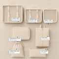 Beige 7-piece travel packing cube set arranged beside a suitcase